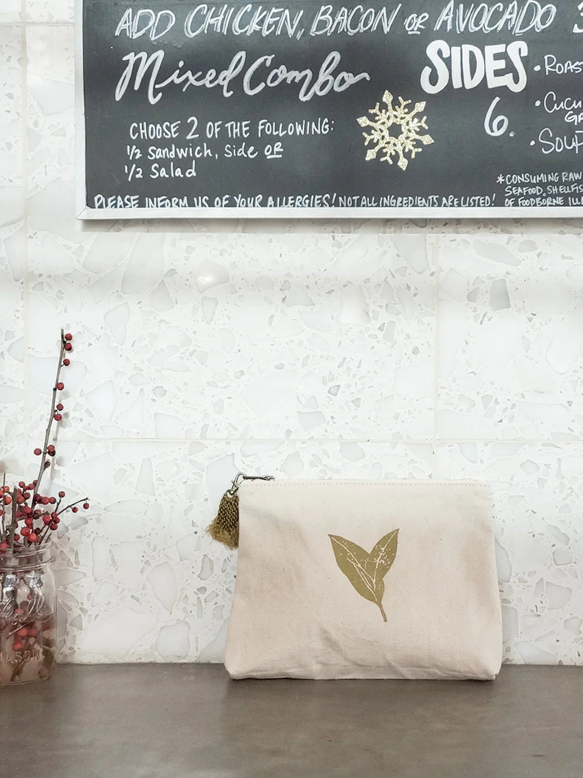 Eco-friendly canvas pouch with leaf print and tassel, on counter at Qu!rk Boutique