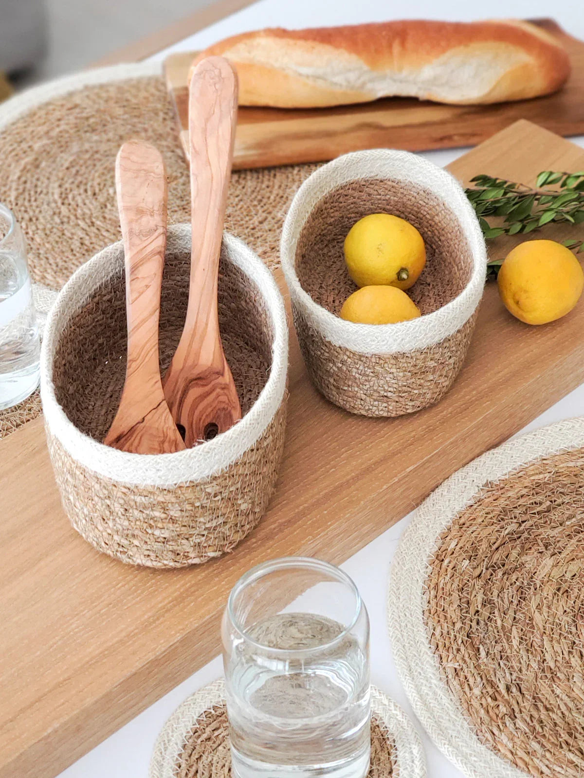 Set of three woven natural fiber bowls on a table with lemons and bread, Qu!rk Boutique