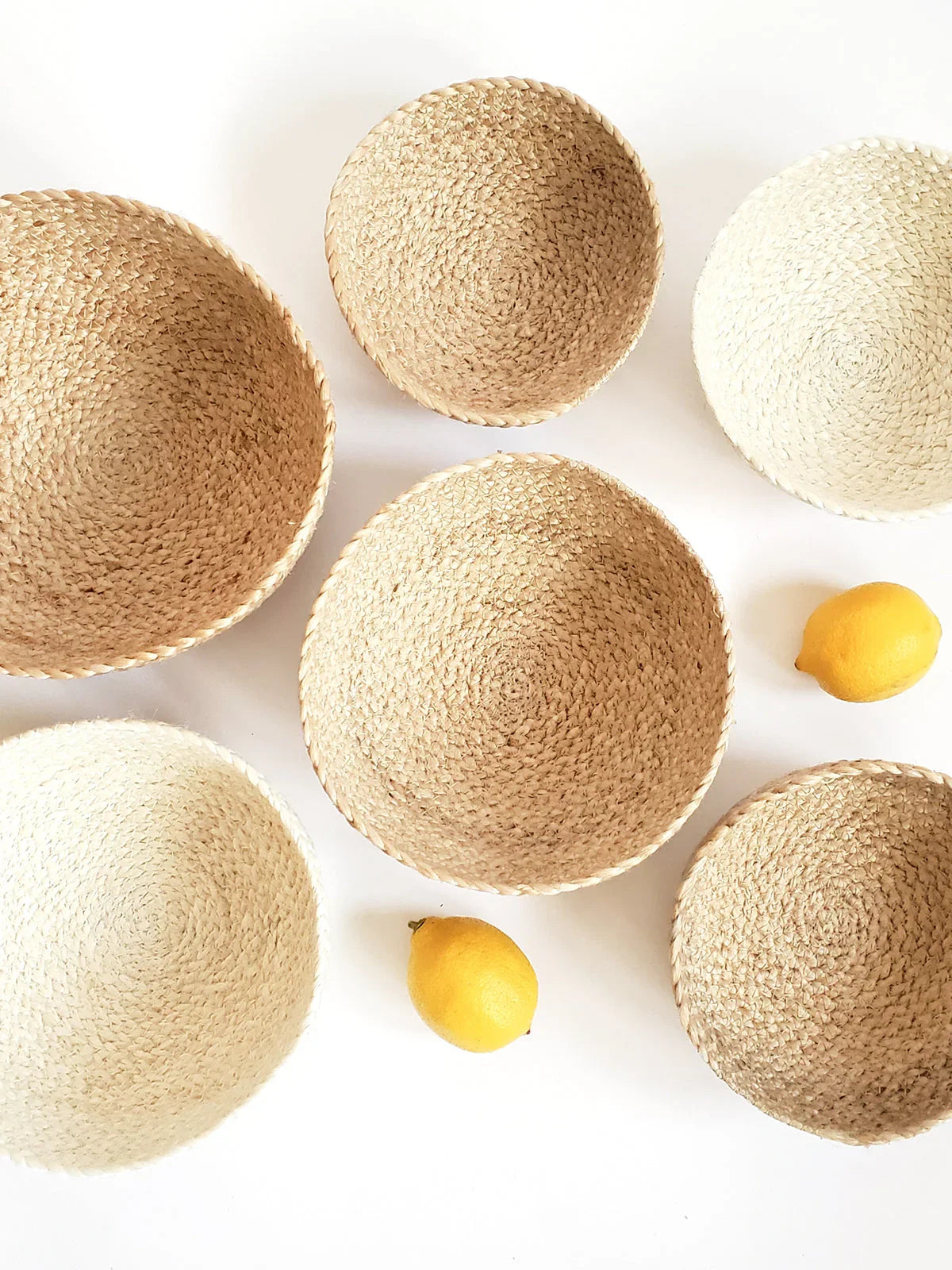 Handwoven natural fiber baskets with fresh lemons on a white background, Qu!rk Boutique.