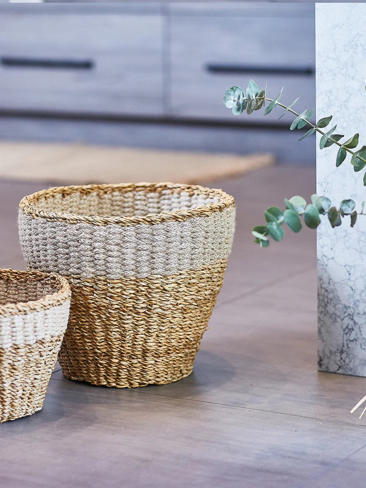 Two woven seagrass planters on a modern floor, eco-friendly home decor from Qu!rk Boutique