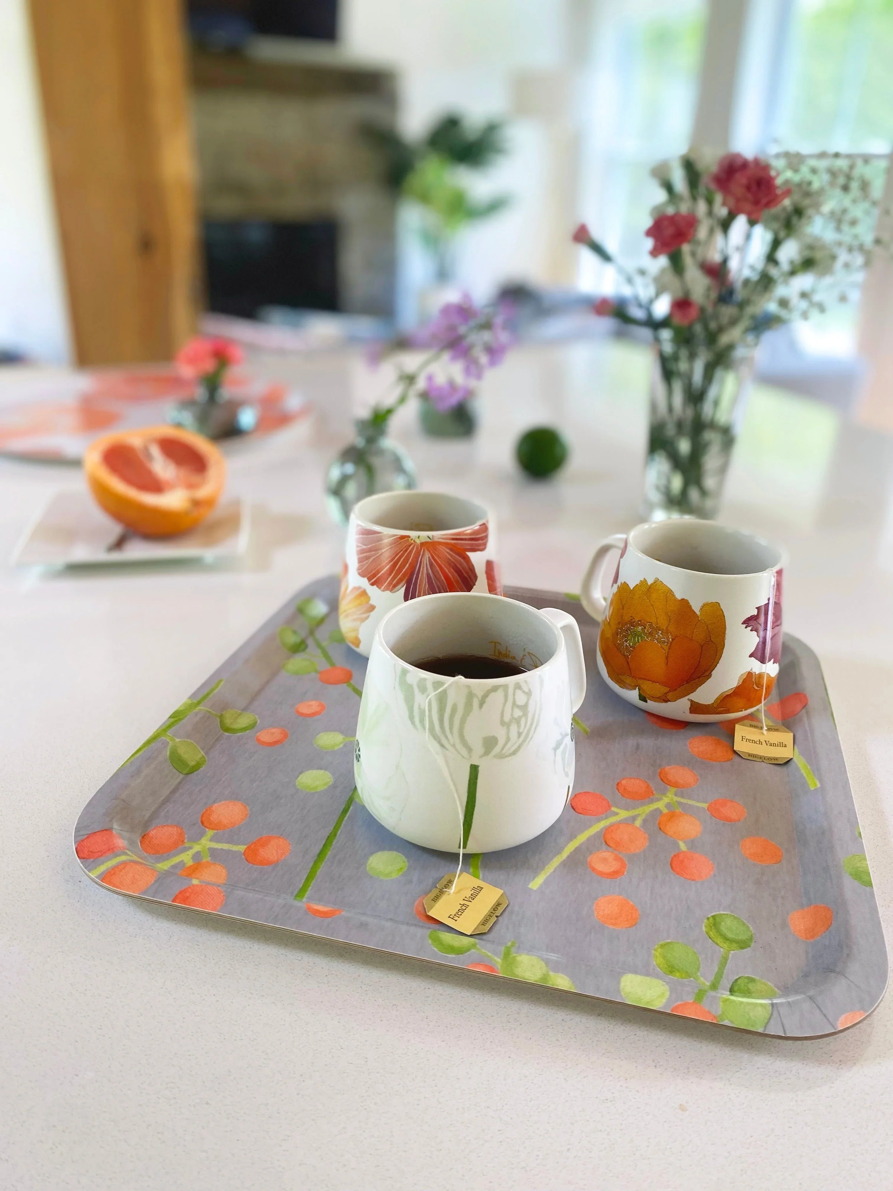 Three floral teacups with French Vanilla tea on a decorative tray on a white kitchen counter