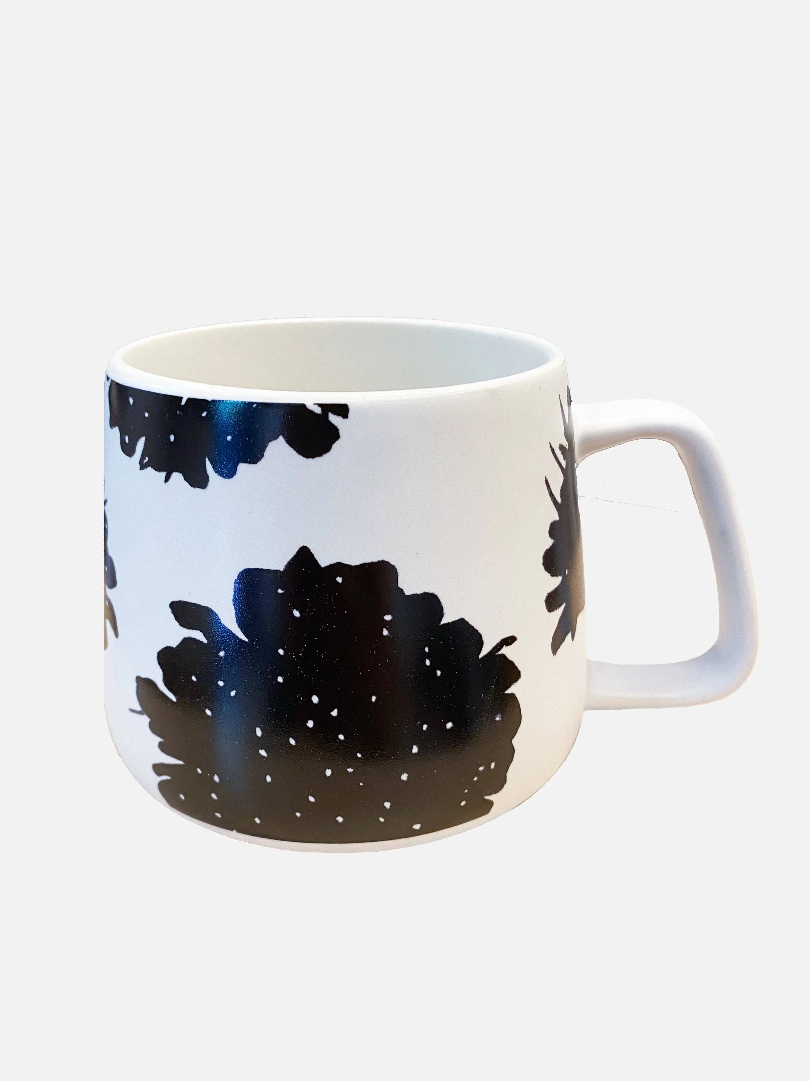 White ceramic mug with black abstract floral pattern and square handle on white background