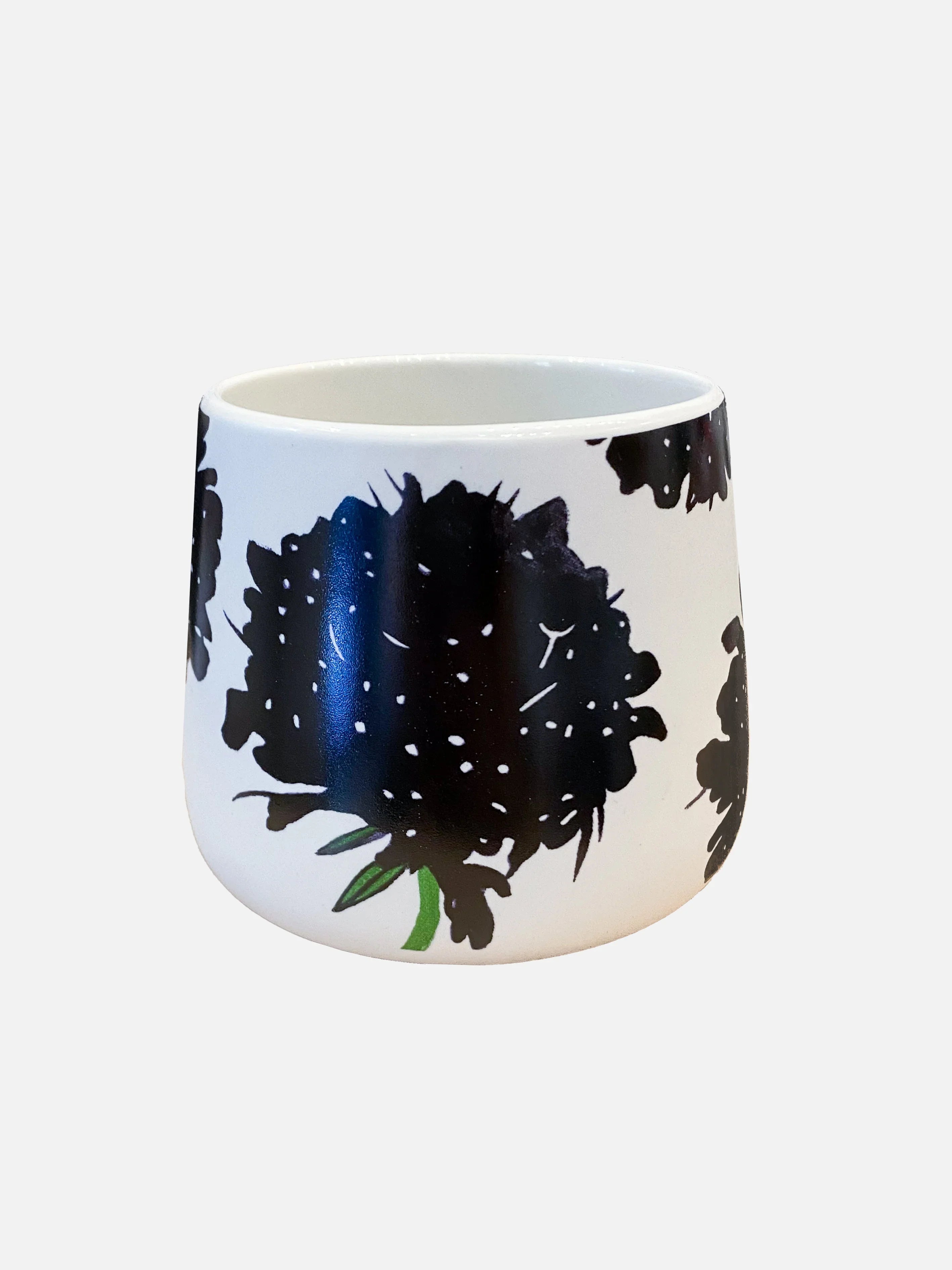 White ceramic mug with black floral design and green stem detail on a plain background
