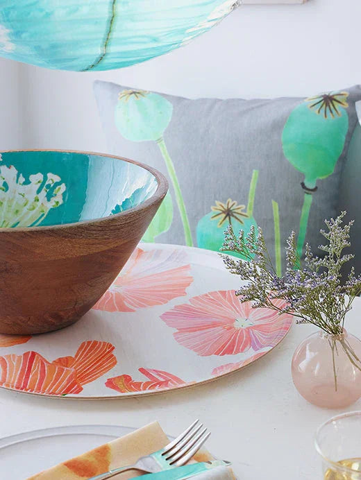 Wooden bowl with turquoise interior on floral hibiscus tray with decorative pillow and small vase