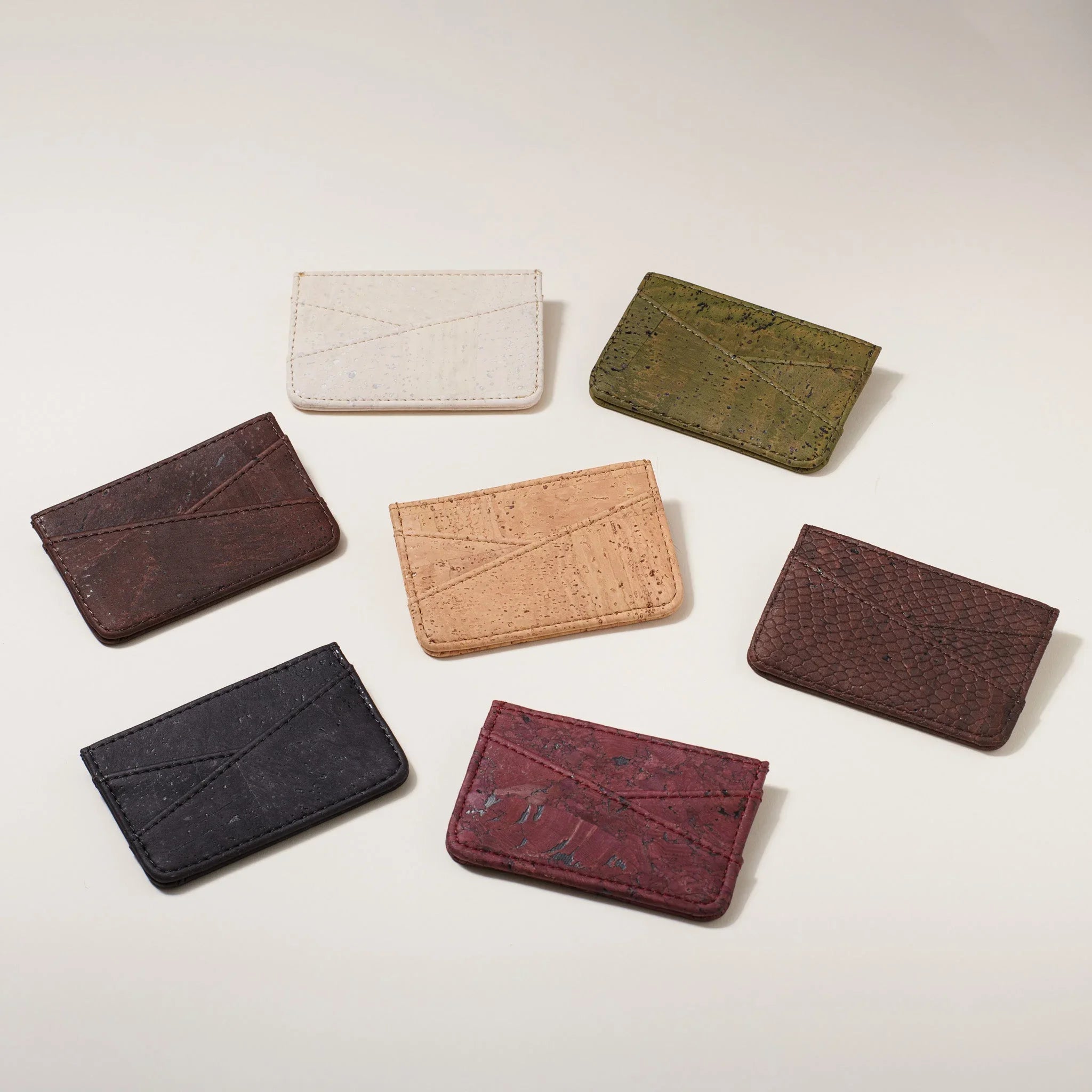 Assorted sustainable cork card holders in neutral and earthy tones on a light background