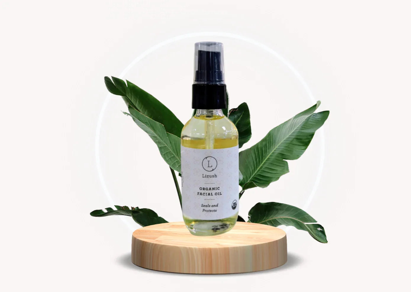 Lizush organic facial oil bottle on wooden platform with green tropical leaves background