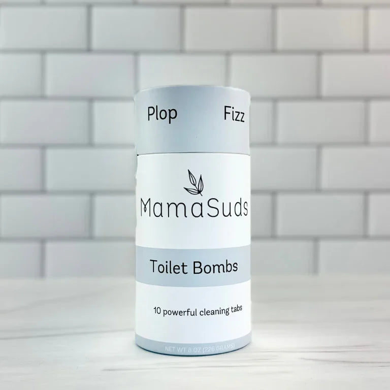MamaSuds Toilet Bombs eco-friendly cleaning tabs in a cylindrical package on white tile background