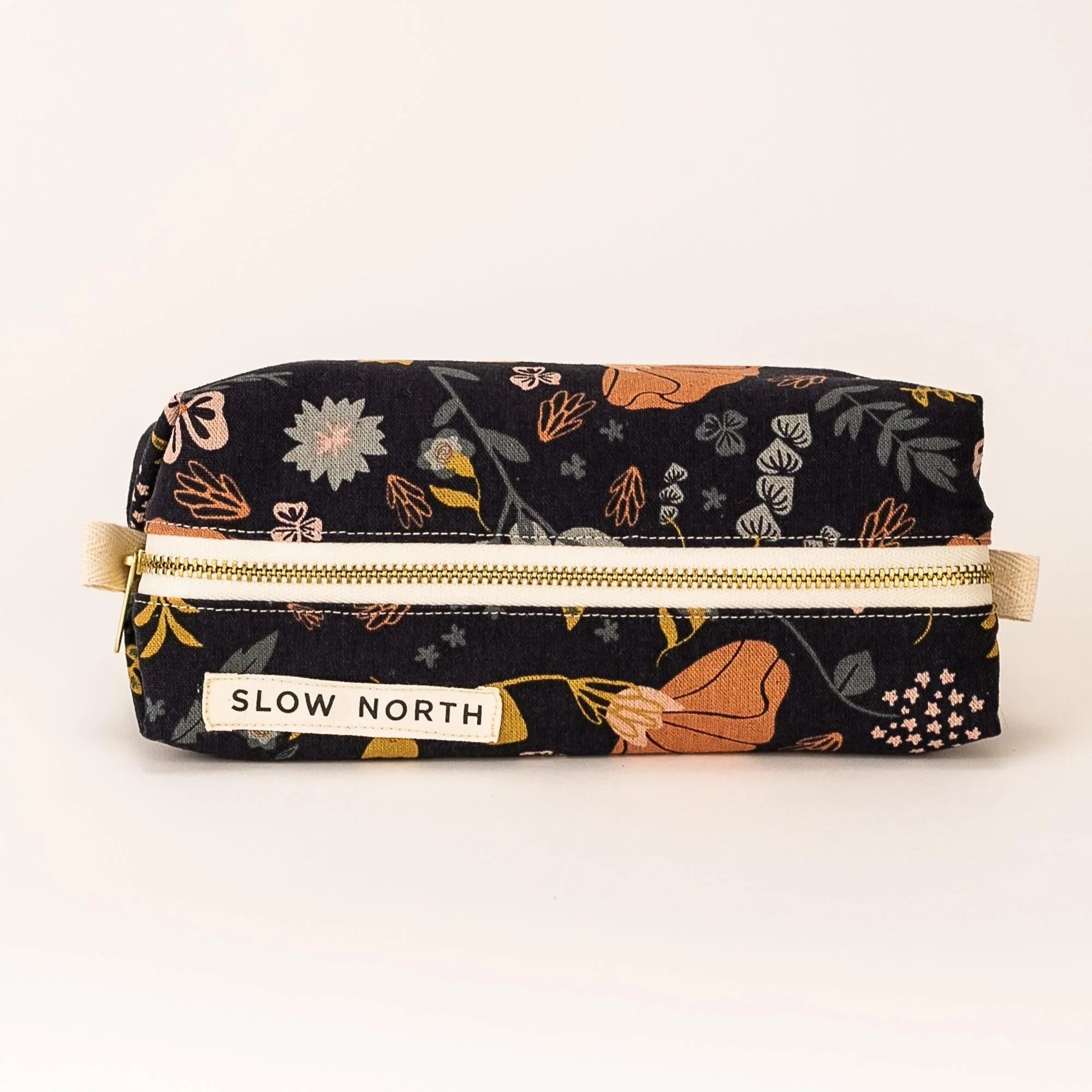 Slow North floral travel pouch with black fabric and zip, featuring orange and pink flowers