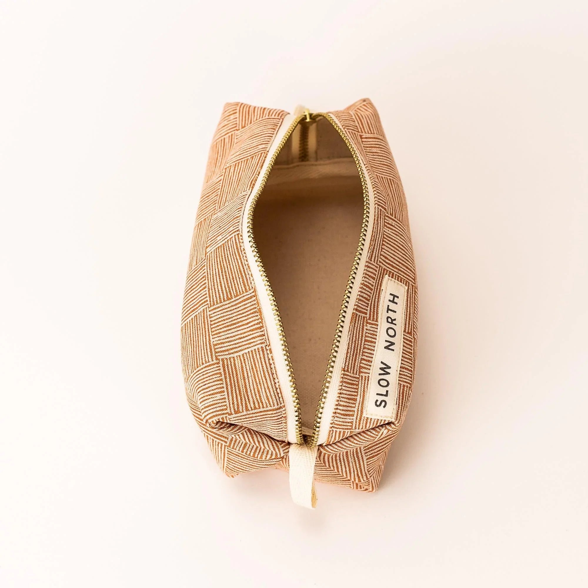 Ethically made copper-patterned travel pouch with zipper, Slow North label, minimalist style
