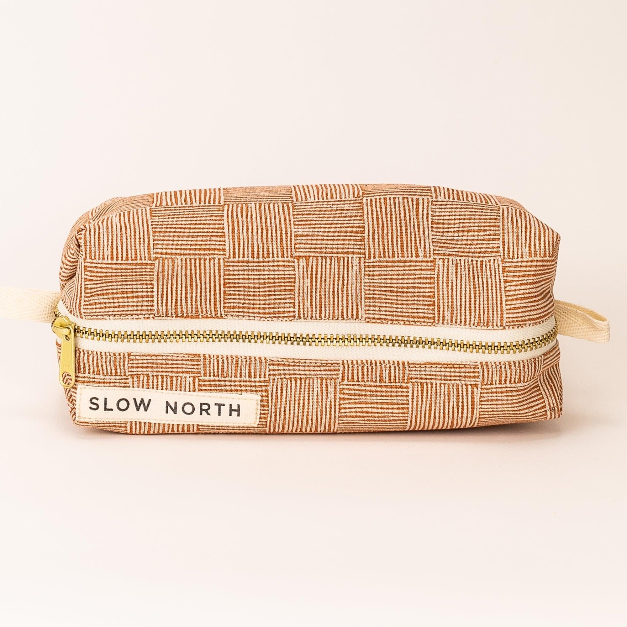Copper Fields textured travel pouch with geometric pattern and Slow North label on beige background