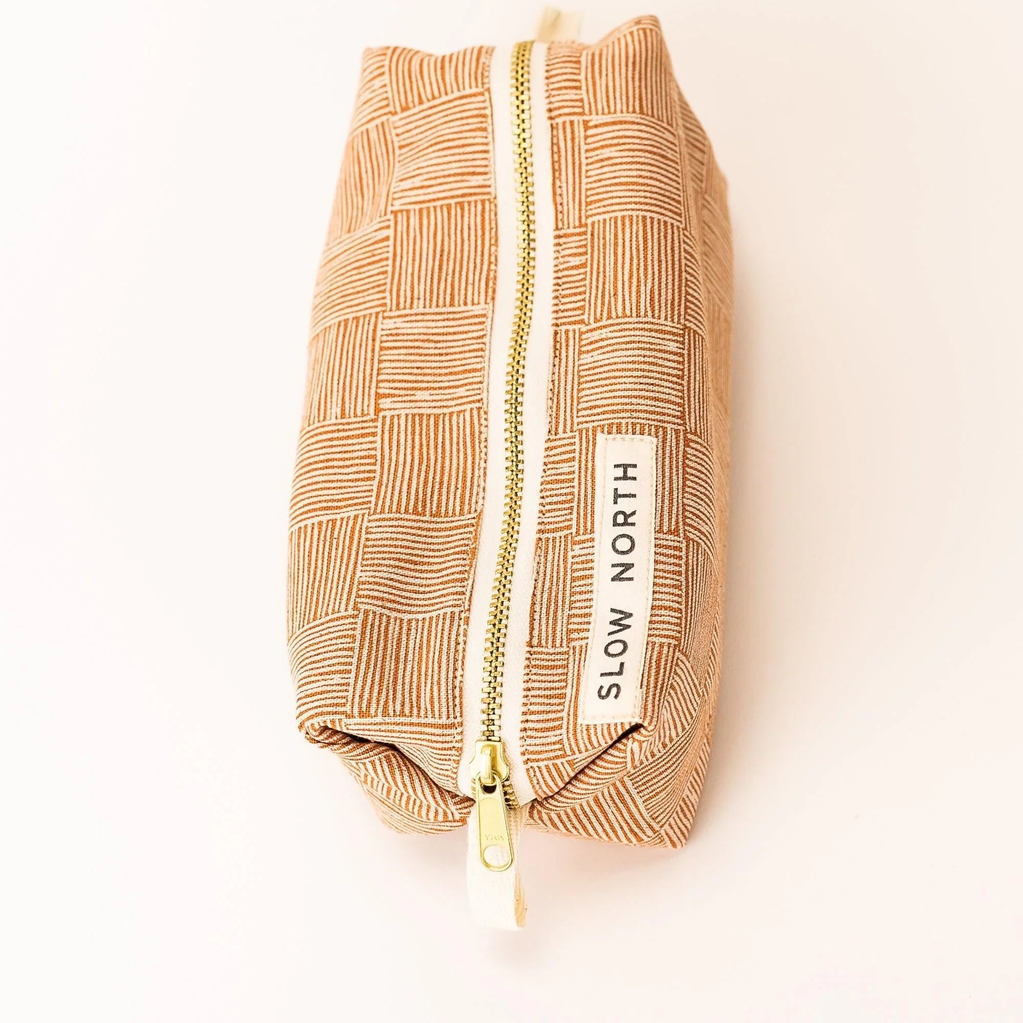 Copper pattern Slow North travel pouch with gold zipper on white background, Qu!rk Boutique