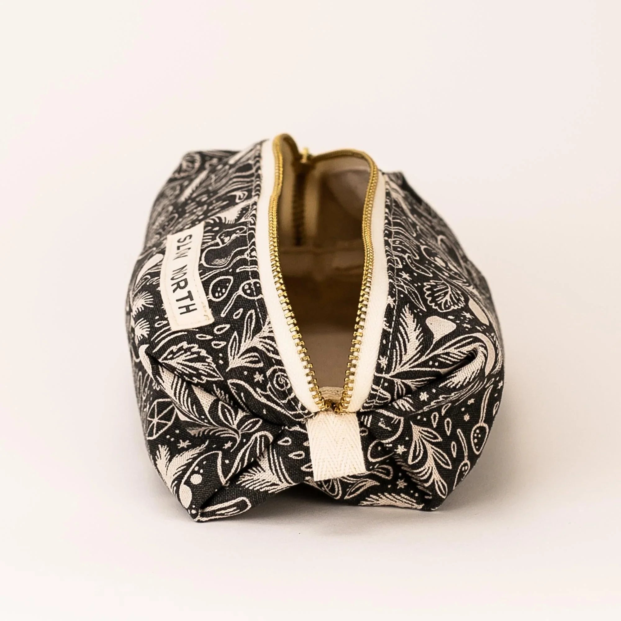 Black and white travel pouch with mystical mushroom pattern and gold zipper by SLOW NORTH