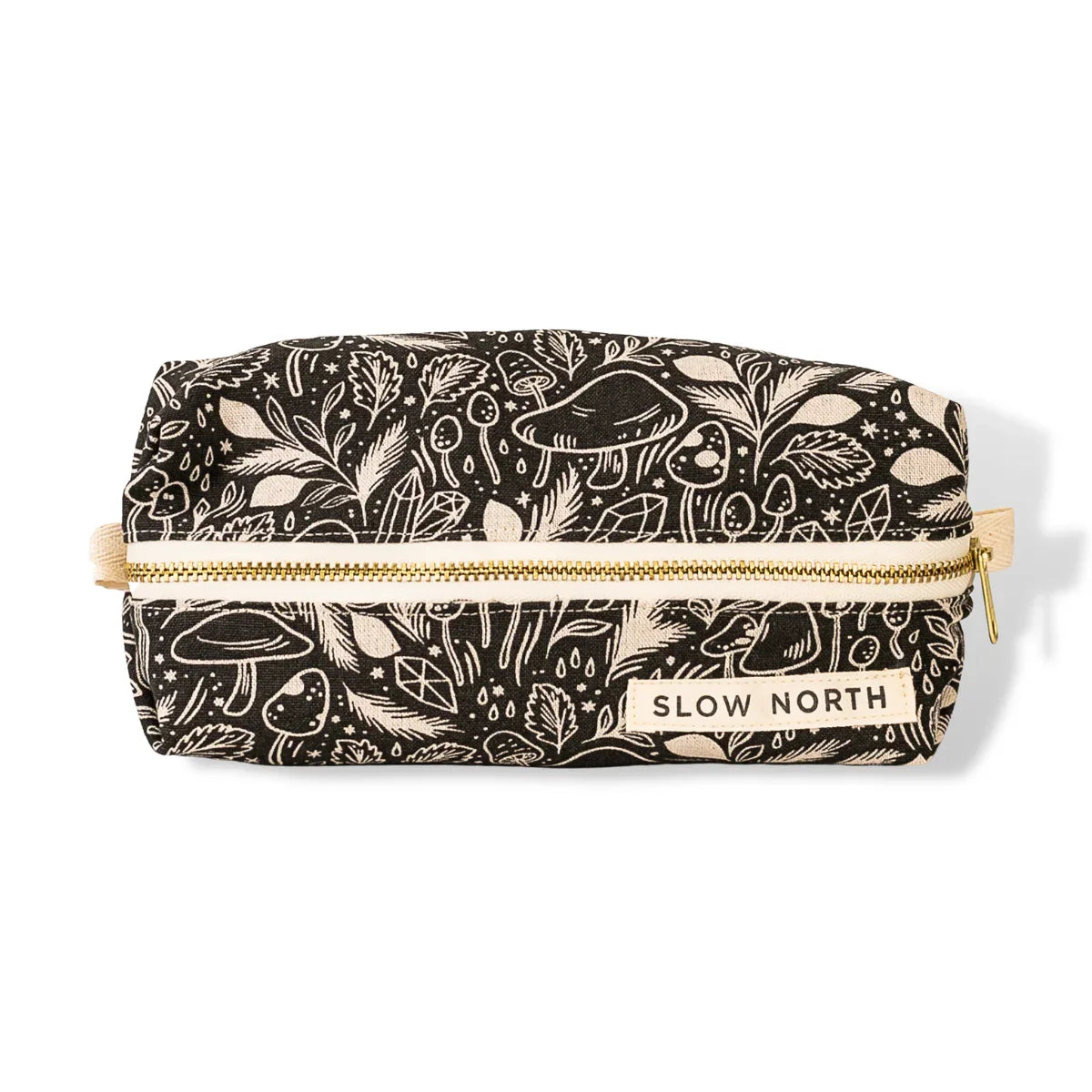 Black travel pouch with white mystical mushroom and leaf pattern, gold zipper, Slow North label