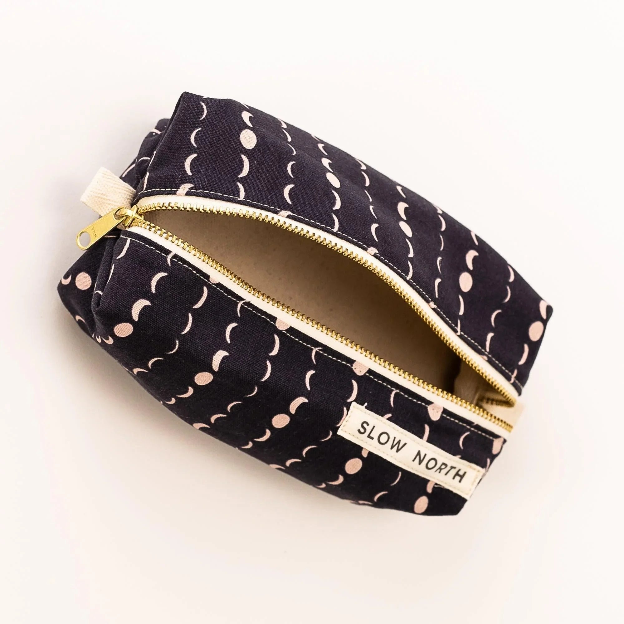 Slow North travel pouch with moon phase print and gold zipper on white background