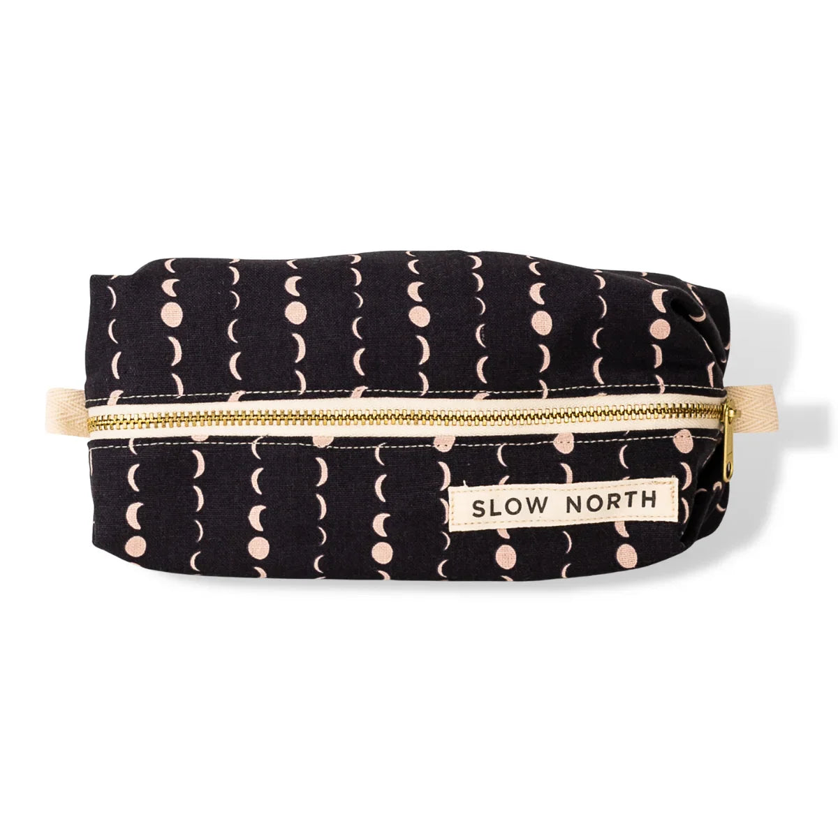 Black travel pouch with gold zipper, crescent moon pattern, and Slow North label
