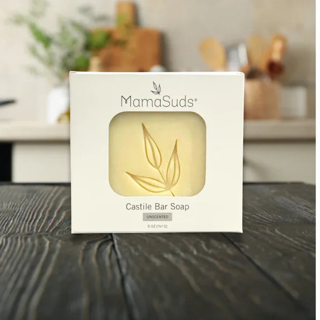 MamaSuds unscented Castile bar soap in eco-friendly packaging on rustic wooden table