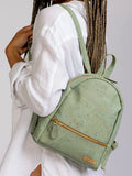 Woman wearing sustainable mint green backpack from Qu!rk Boutique, styled with white shirt.