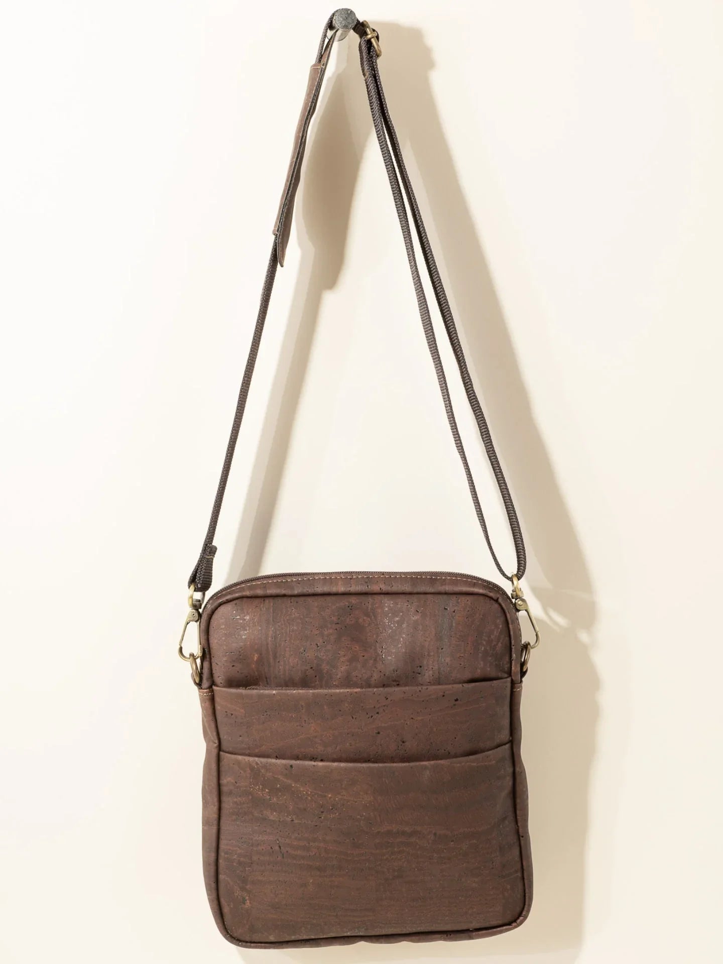 Sustainable brown crossbody bag with adjustable strap, displayed against a neutral backdrop at Qu!rk Boutique.