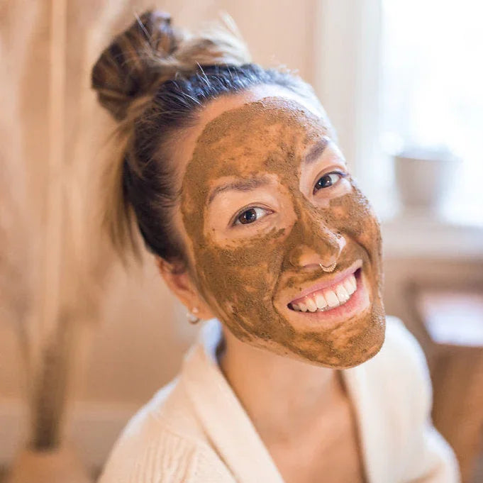 Smiling woman with natural face mask, cozy setting at Qu!rk Boutique & Gift Shop