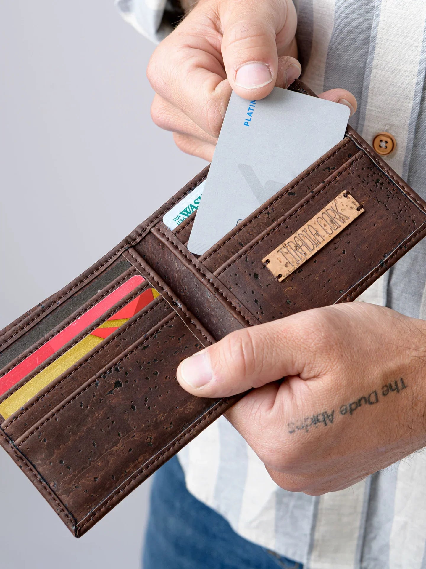Hand holding eco-friendly cork wallet with cards, featuring sustainable design from Qu!rk Boutique