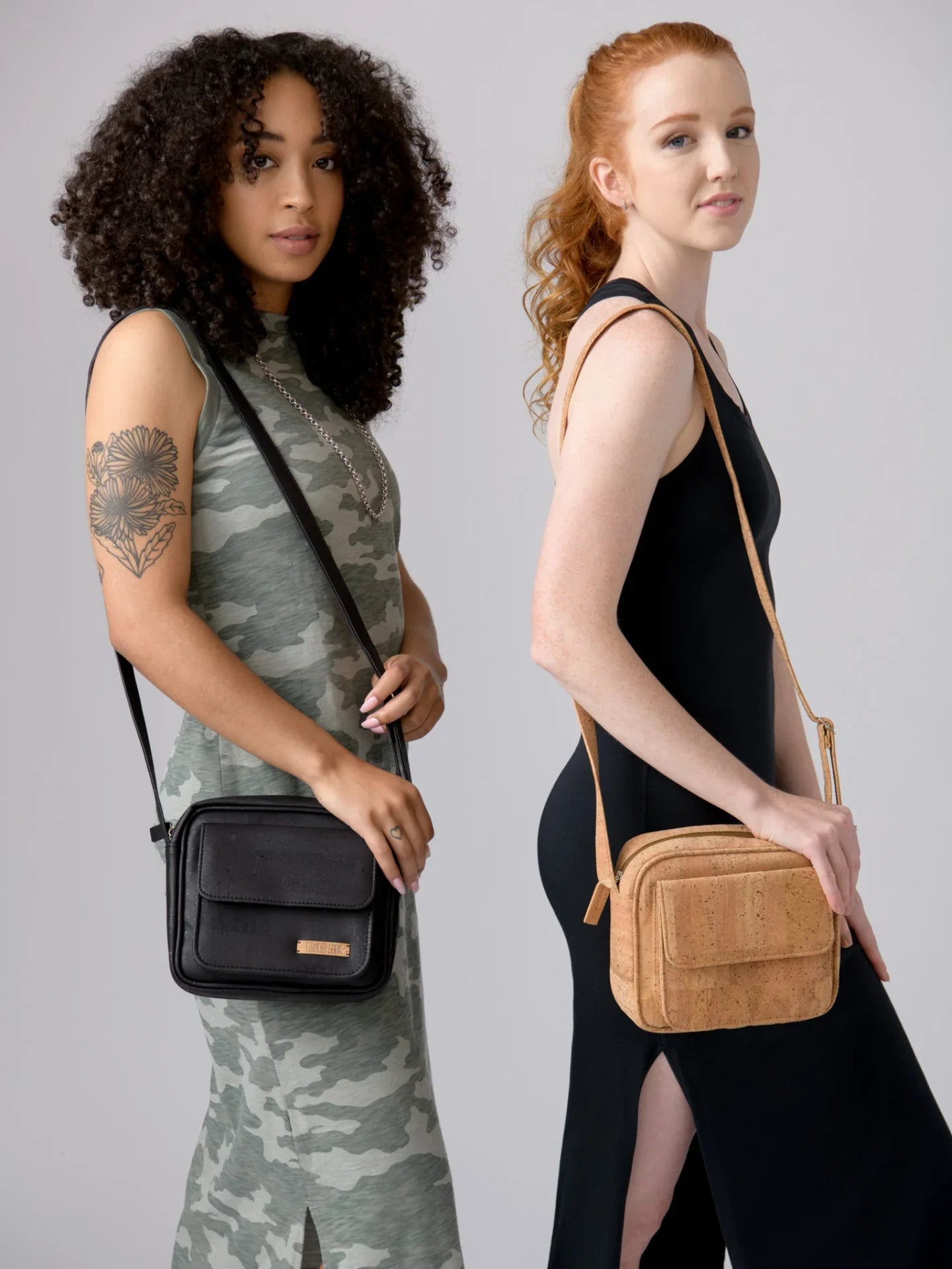 Two women modeling vegan crossbody bags at Qu!rk Boutique, with one in camo dress and one in black dress