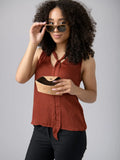 Woman in rust sleeveless top wearing sunglasses, holding cork case, Qu!rk Boutique style
