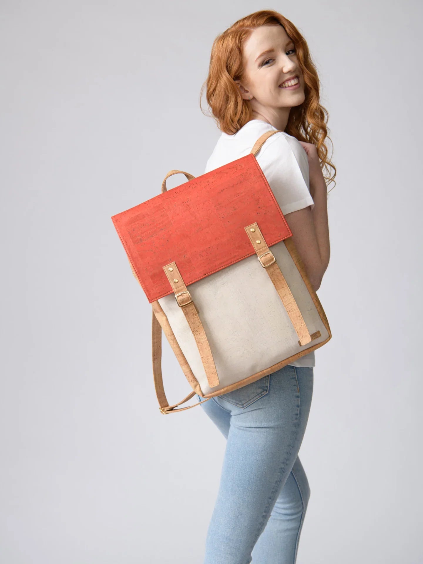Smiling woman wearing a cork and canvas backpack, sustainable fashion at Qu!rk Boutique