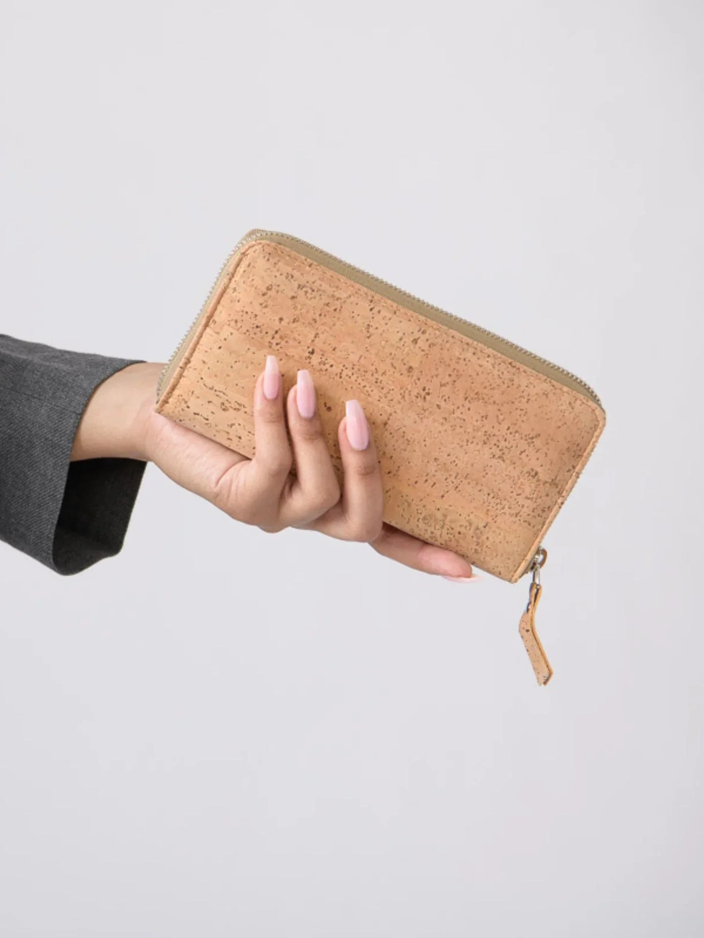 Hand holding a natural cork wallet, sustainable accessory from Qu!rk Boutique