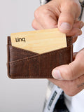 Hand holding brown vegan cork card wallet with bamboo card, eco-friendly Qu!rk Boutique accessory