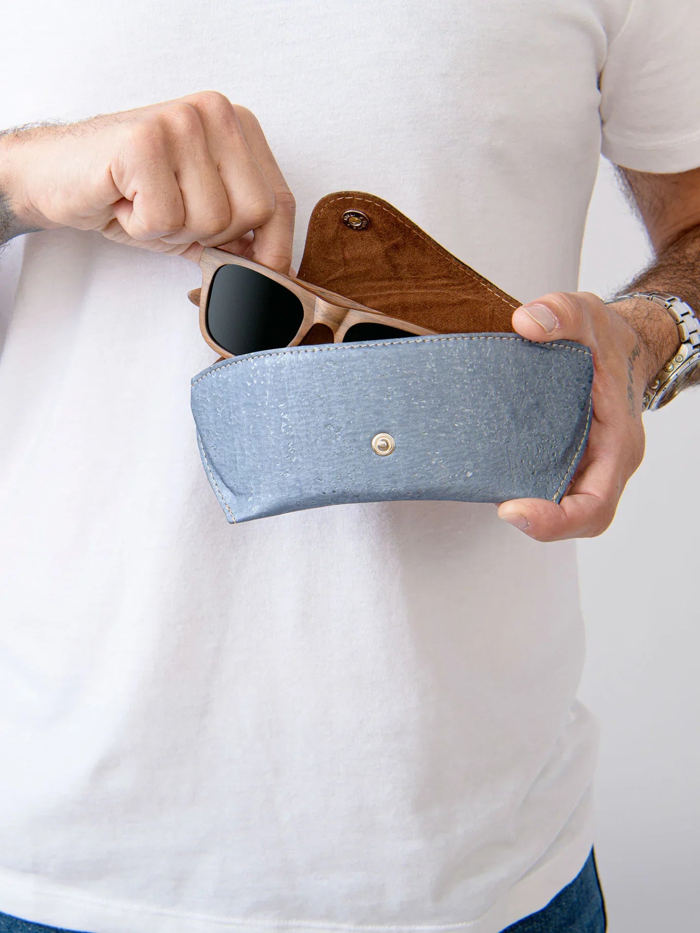 Hand holding wood sunglasses and gray eco-friendly case at Qu!rk Boutique