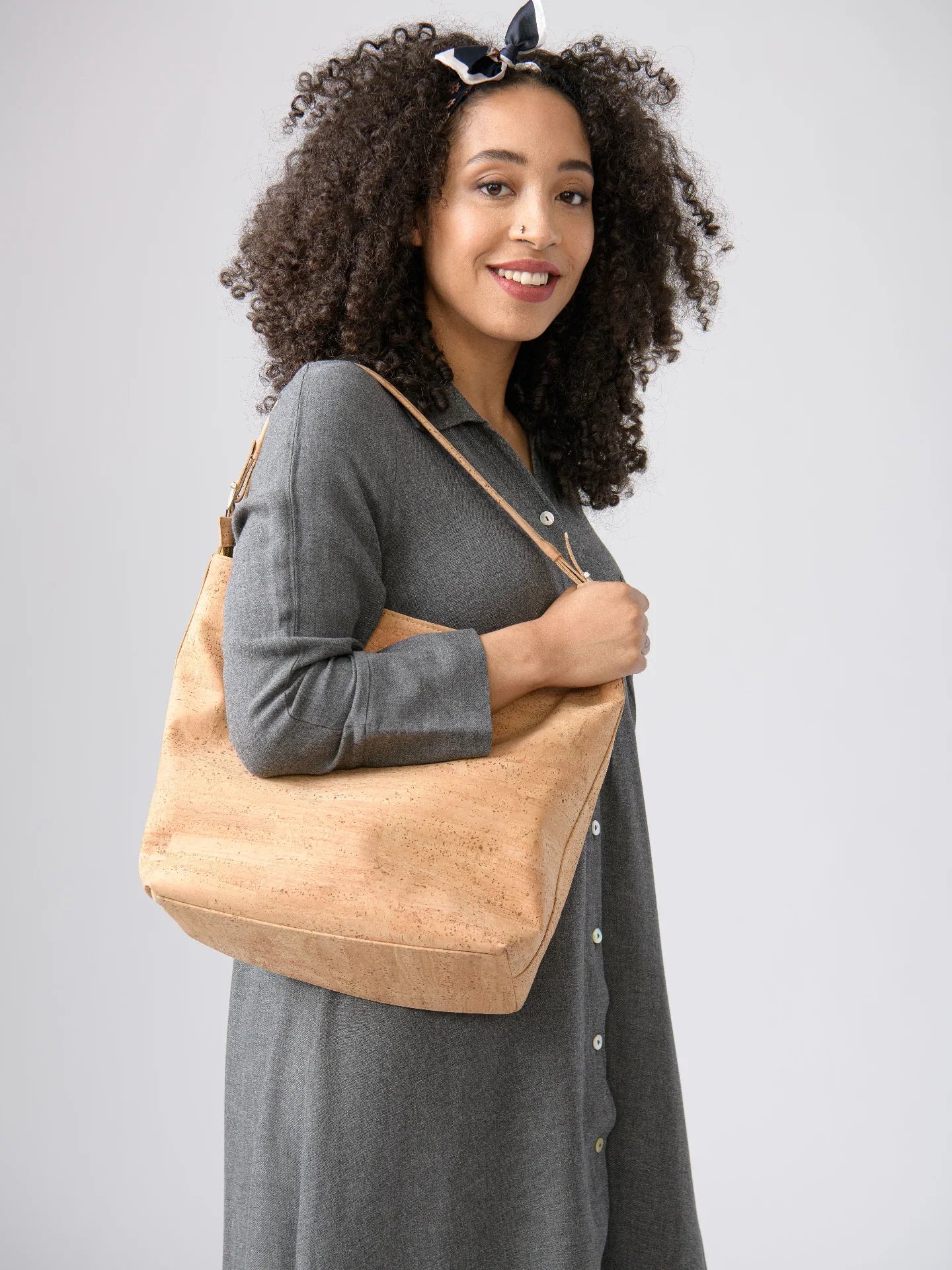 Woman in grey dress holding a sustainable cork handbag, styled by Qu!rk Boutique