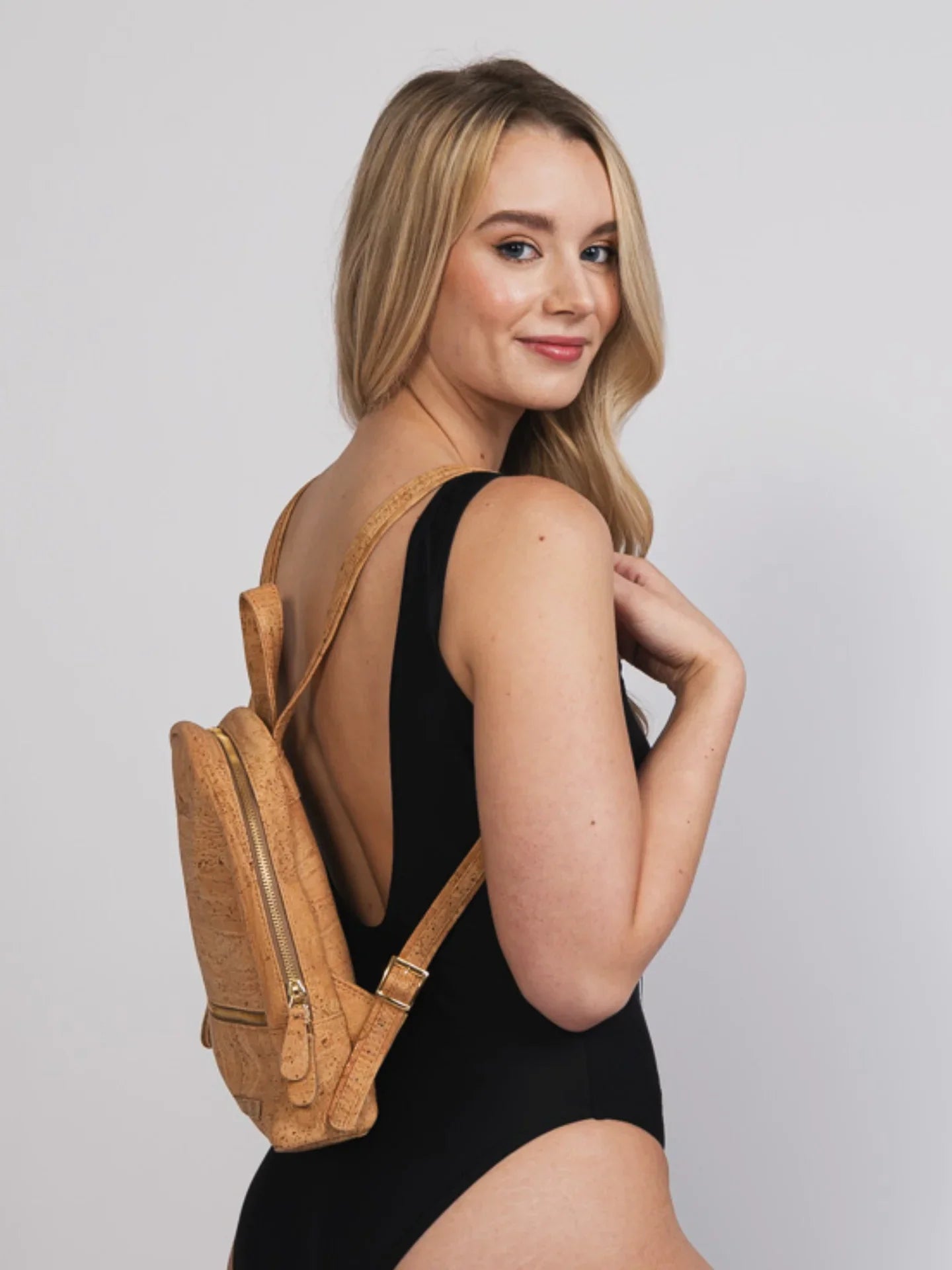 Woman in black bodysuit modeling cork mini backpack, sustainable fashion at Qu!rk Boutique