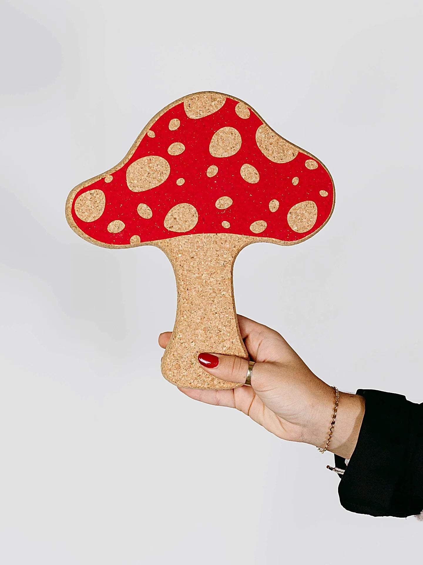 Hand holding cork mushroom-shaped trivet with red cap, quirky eco gift from Qu!rk Boutique