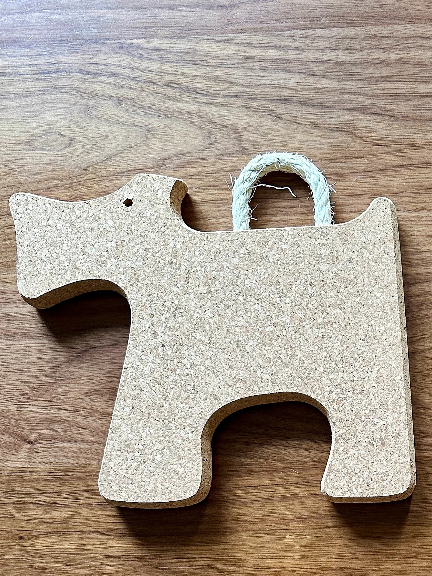 Cork dog-shaped trivet with rope handle on wood surface, eco-friendly Qu!rk Boutique gift