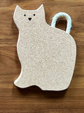 Cork cat-shaped trivet with rope tail on wood surface, sustainable gift from Qu!rk Boutique