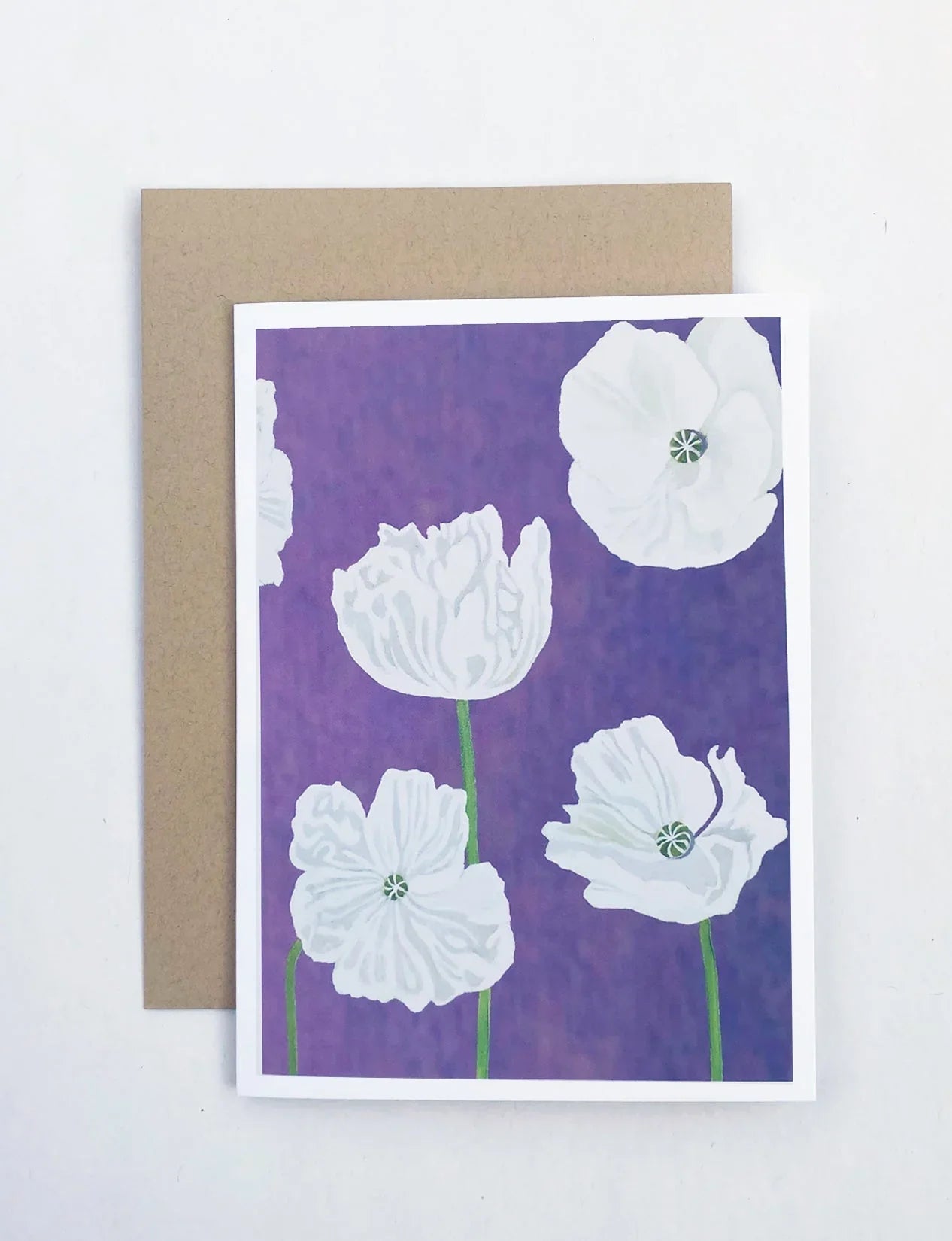 Notecard with white poppy flowers on a violet background and a brown envelope