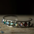 Silver cosmic bracelet with colorful galaxy cabochons on rustic wood, Qu!rk Boutique jewelry