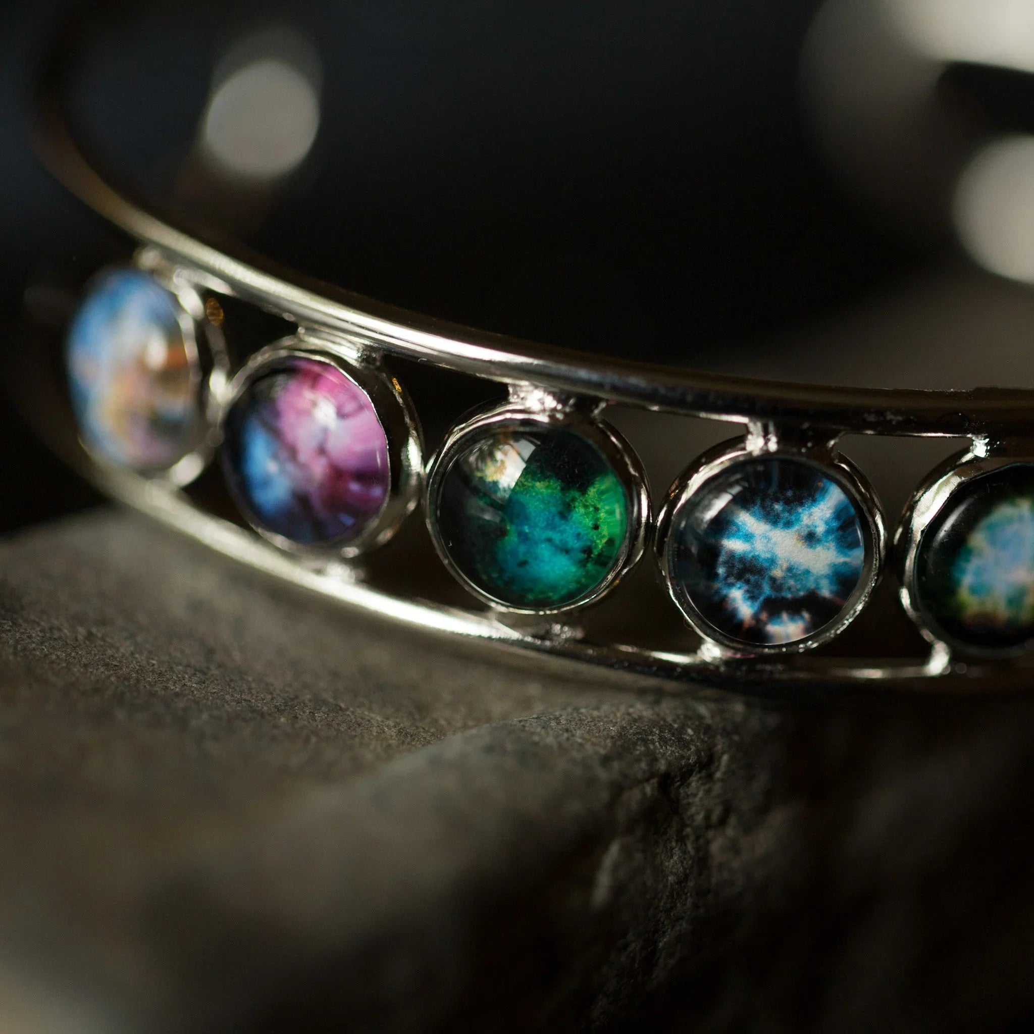Close-up of a cosmic-inspired bracelet with colorful round glass charms, Qu!rk Boutique jewelry