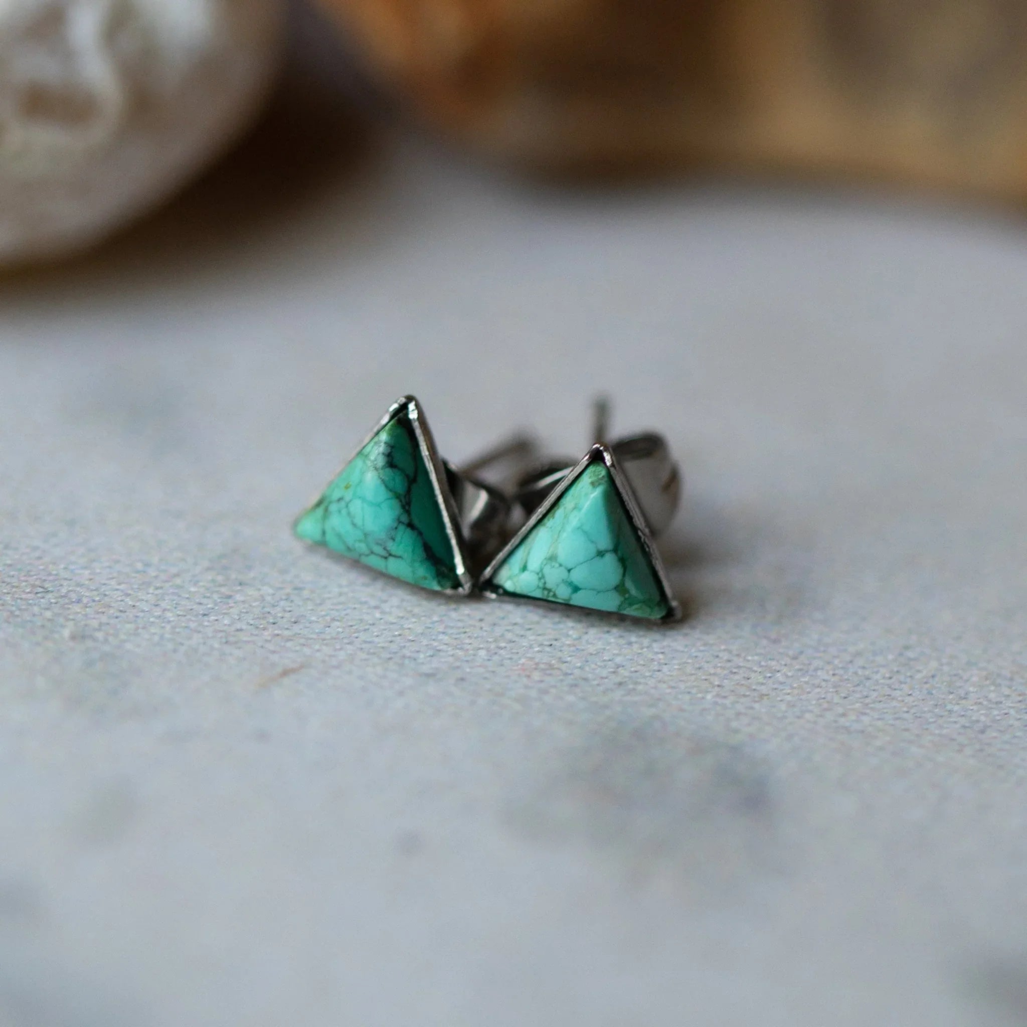 Turquoise triangle stud earrings with silver trim on neutral background, Qu!rk Boutique jewelry