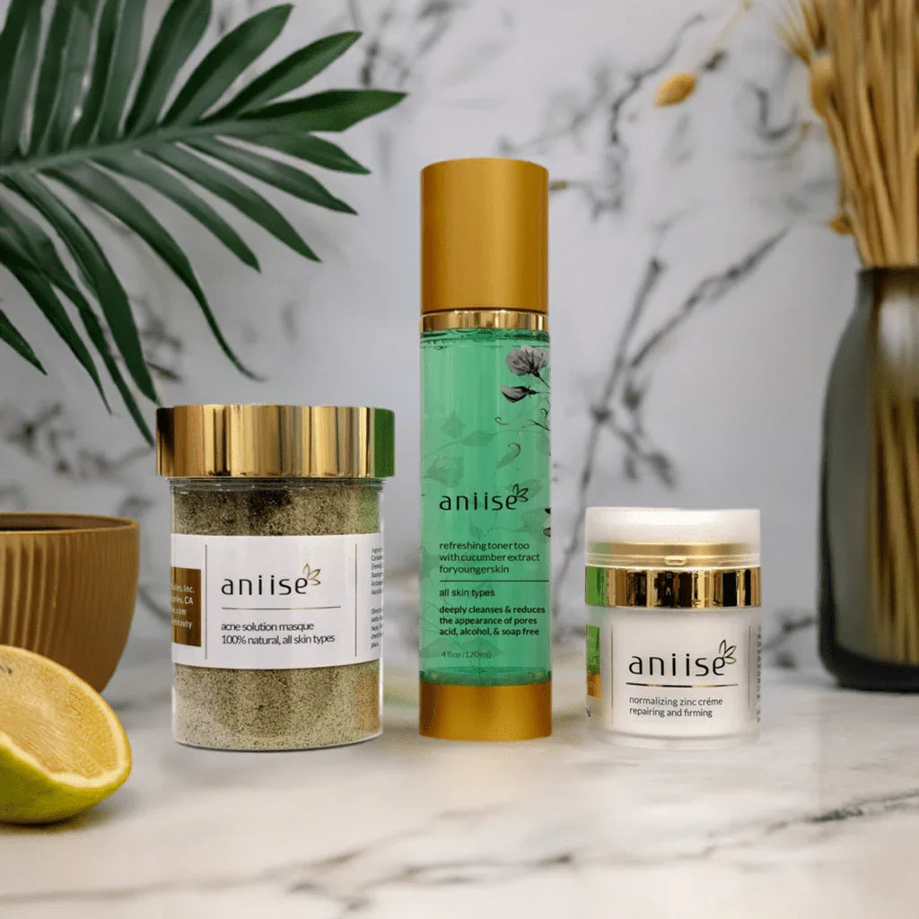 Anise acne solution kit with toner, masque, and zinc creme on marble table amid plants at Qu!rk Boutique