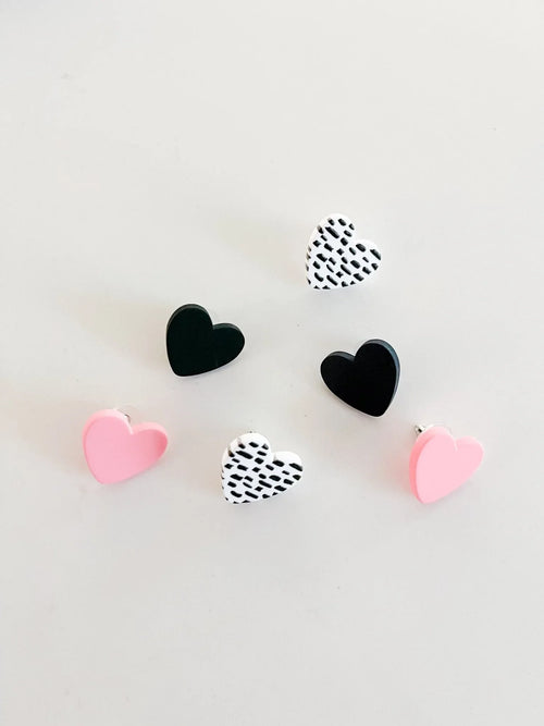Set of heart-shaped earrings in pink, black, and white patterns on white background, Qu!rk Boutique