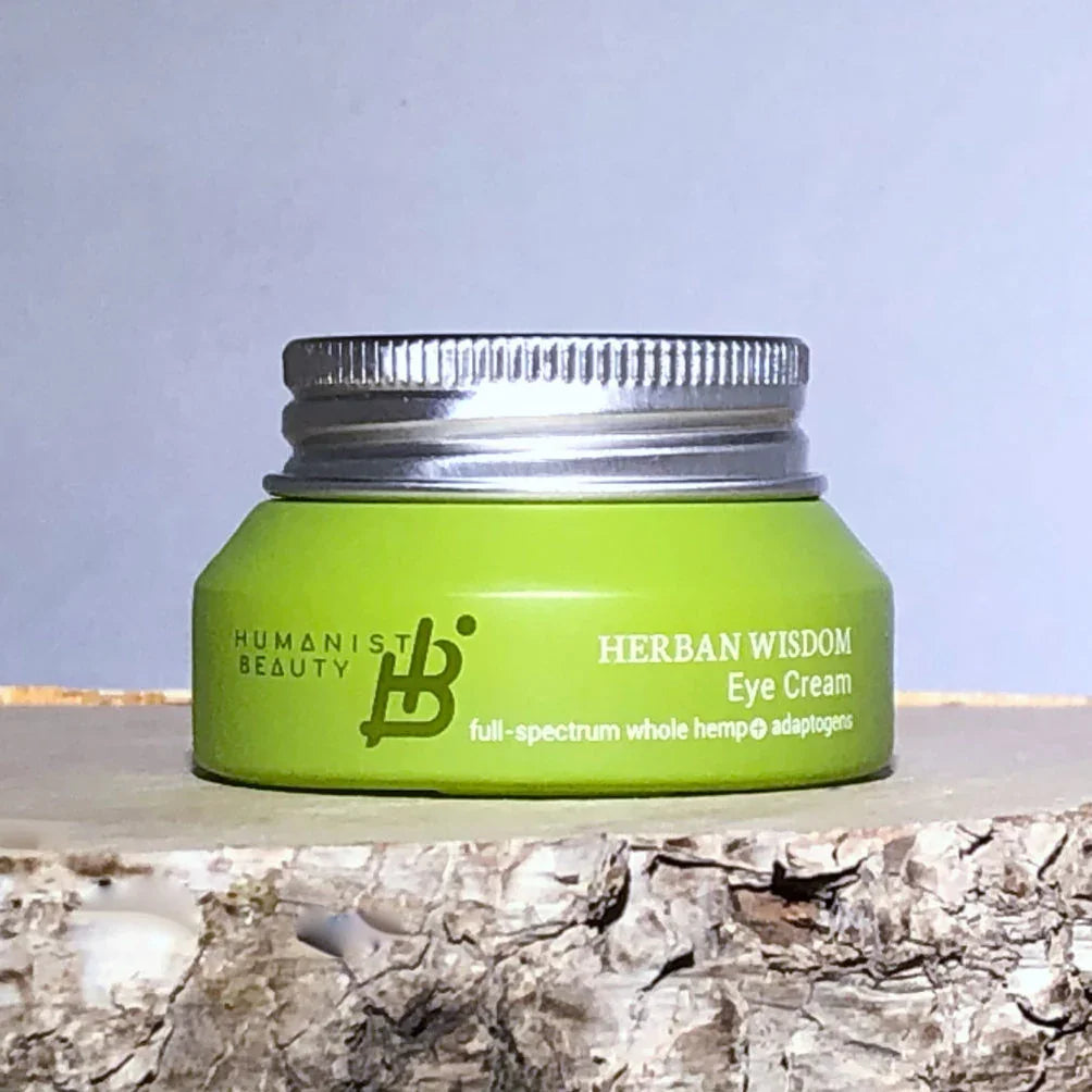 Herban Wisdom Eye Cream jar by Humanist Beauty on birch wood, eco-friendly boutique skincare