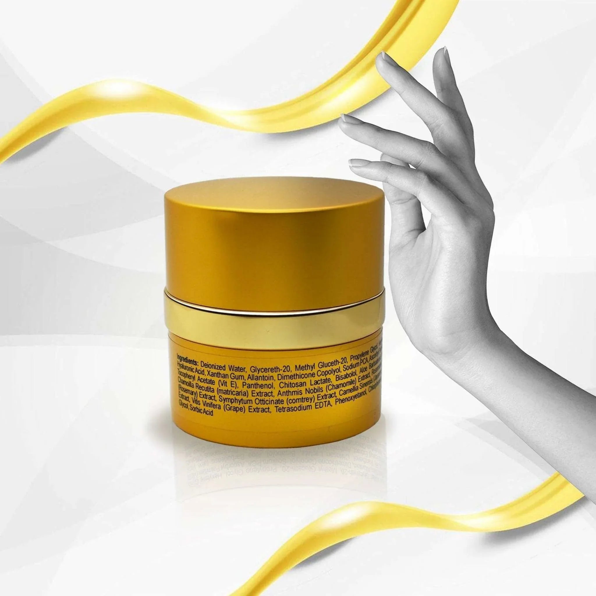 Gold anti-aging serum jar with ingredients label, artistic hand, and swirling yellow ribbon, Qu!rk Boutique