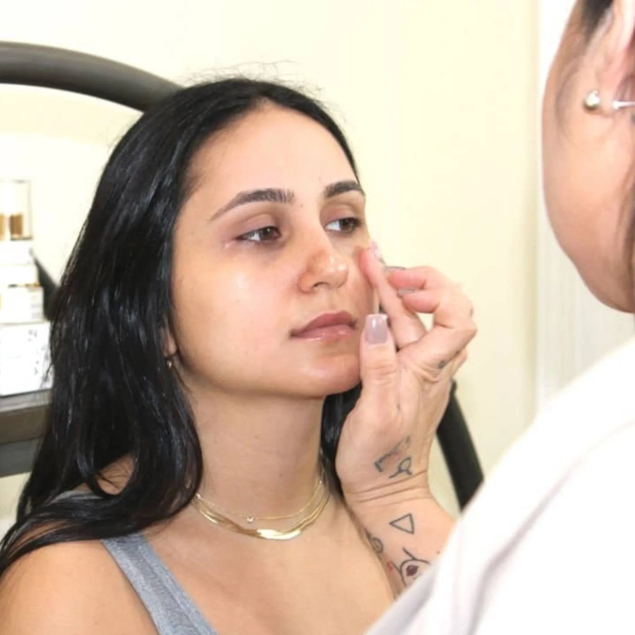 Woman applying anti-puffiness eye serum at Qu!rk Boutique, promoting skincare and self-care