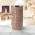 Brown travel tumbler with white floral line art and clear lid on marble countertop