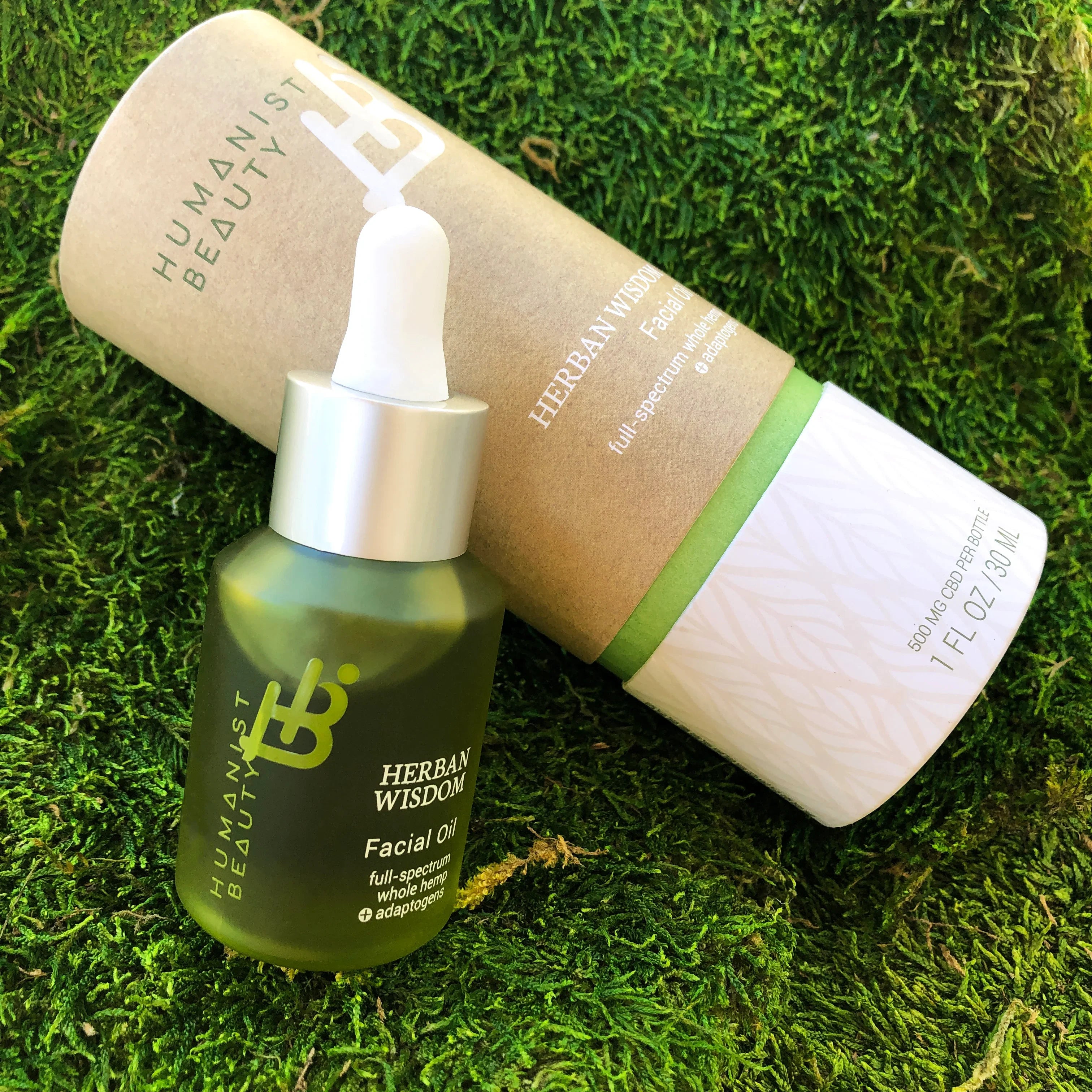 Herban Wisdom Facial Oil by Humanist Beauty with eco-friendly packaging on green moss