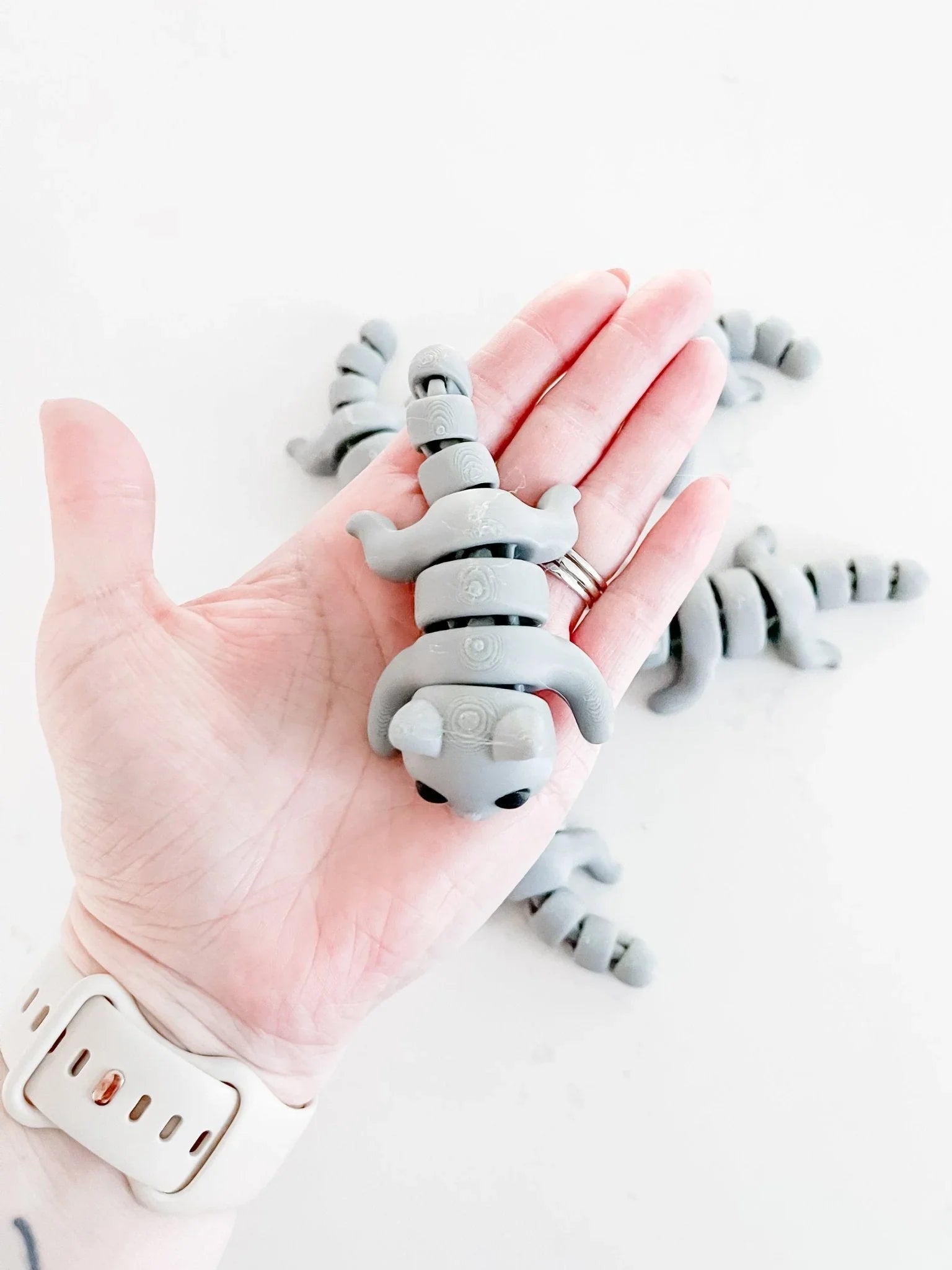 Hand holding a gray baby cat fidget toy, quirky eco-friendly gift at Qu!rk Boutique