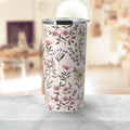 Floral pattern insulated tumbler with pink, yellow, and purple flowers on a light background placed on a marble surface