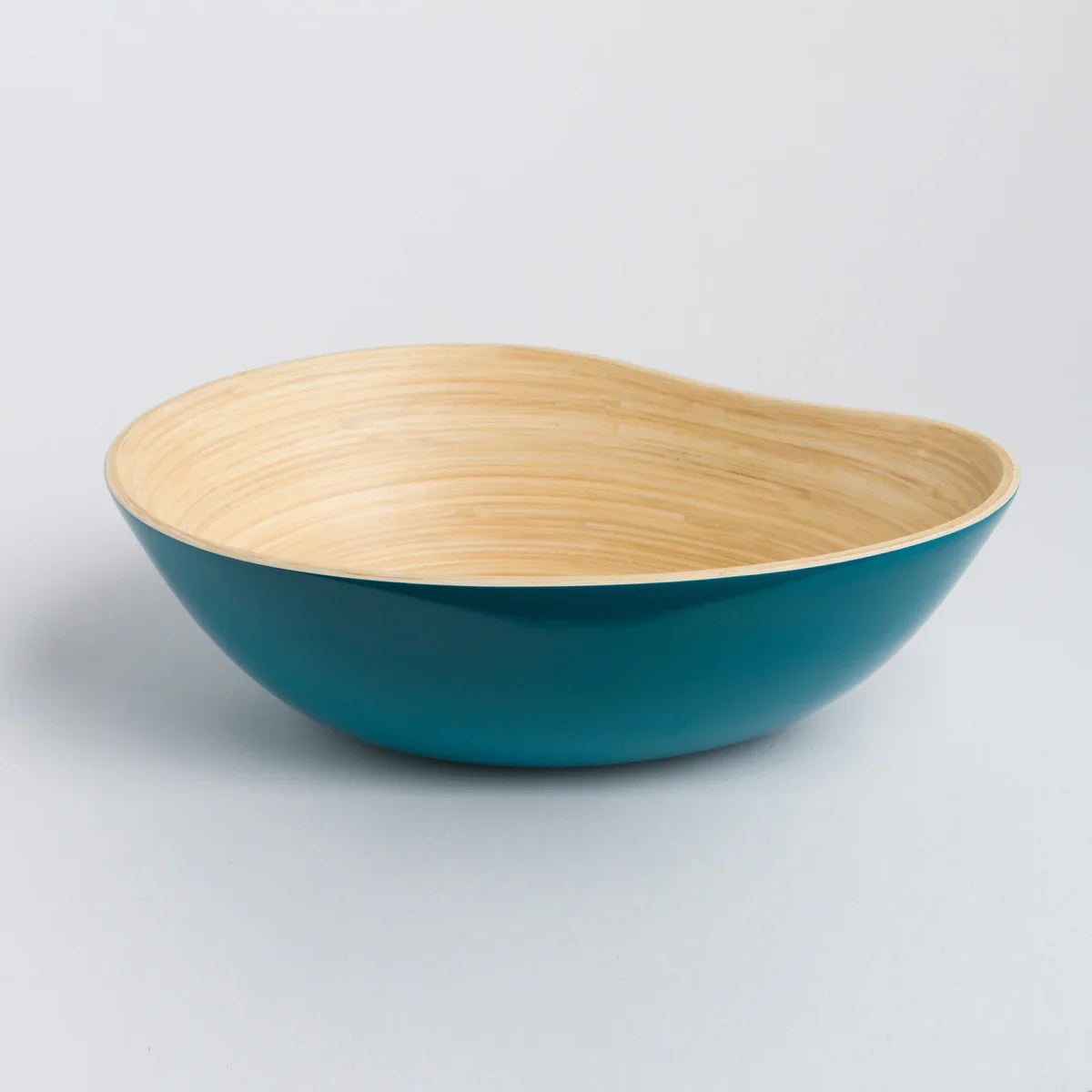 Handmade bamboo bowl with natural interior and glossy teal exterior on white background