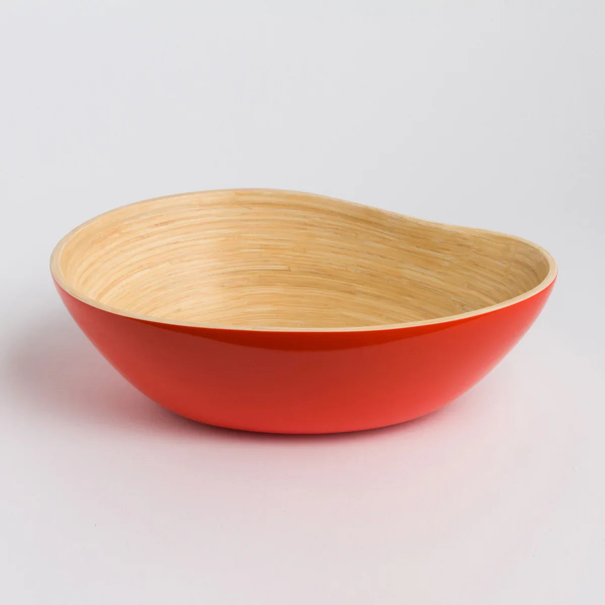 Artist-designed bamboo bowl with bold red exterior and natural wood interior on white background